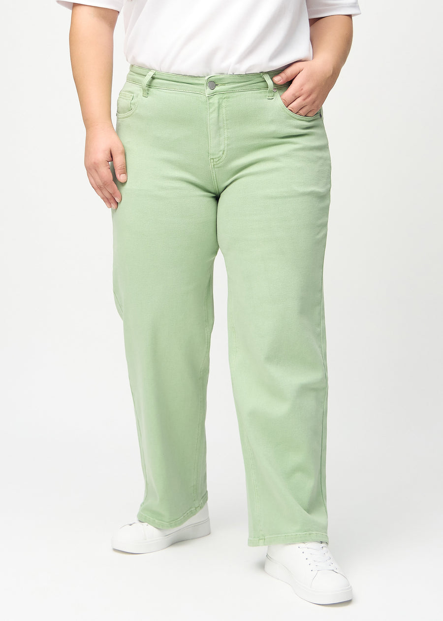 Lysegrønne loose jeans, modelnavn Mints, som er løstsiddende med masser af vidde i benene på en plus-size model, set forfra.