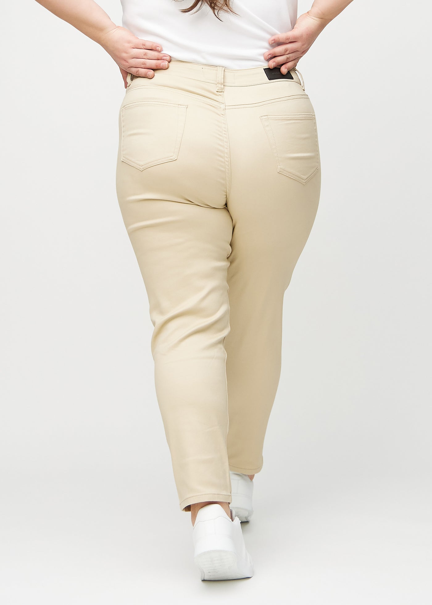 Beige slim jeans set bagfra på en plus-size model, så man kan se hele produktet.