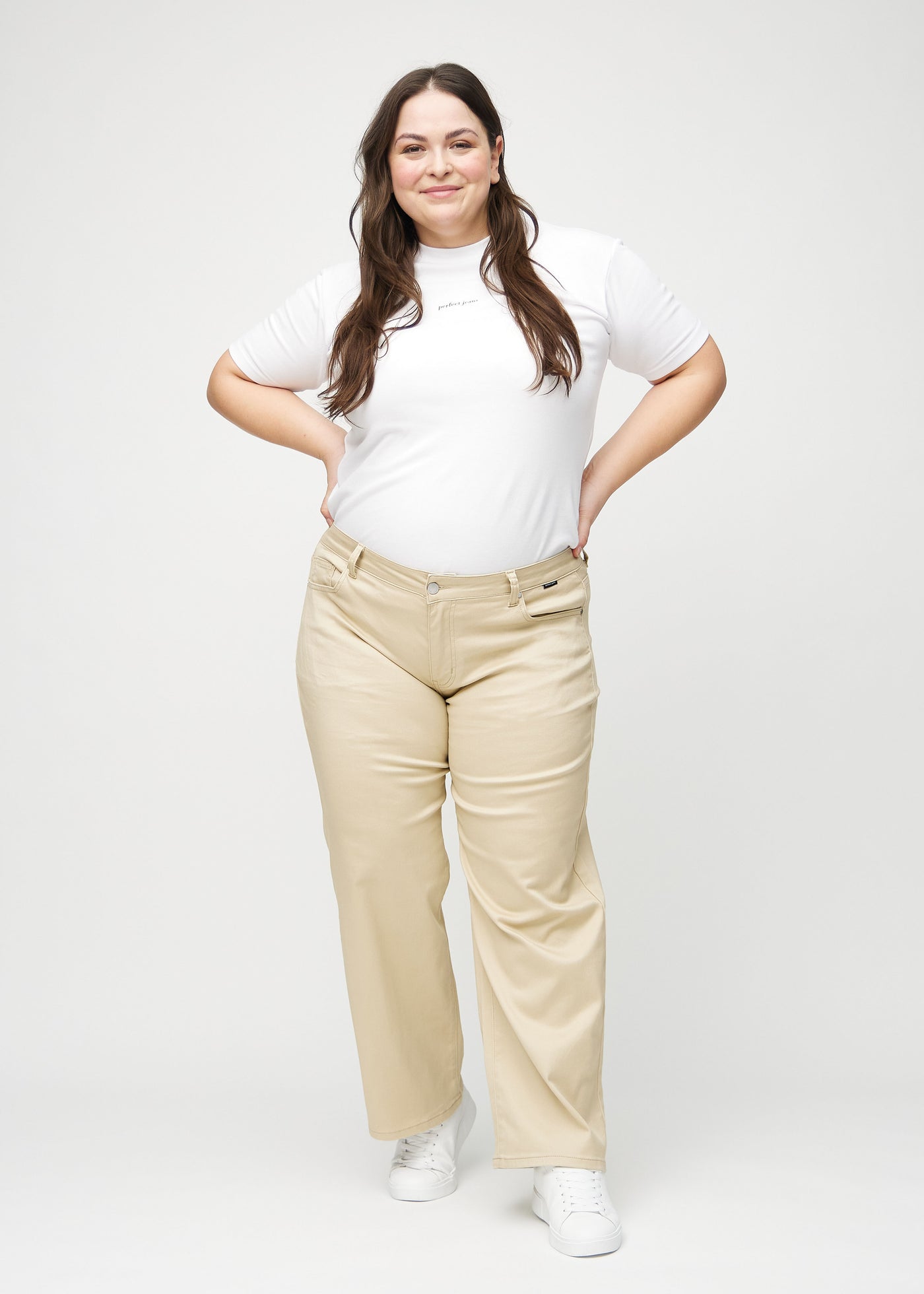 Fuldt billede af en plus-size model i beige loose jeans.