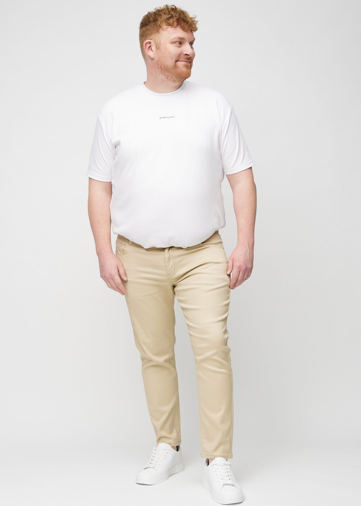Fuldt billede af en plus-size model i beige slim jeans.