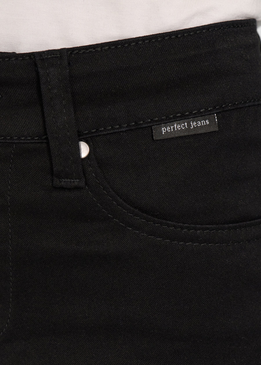 Forlommen på et par sort jeans, hvor man kan se logoet.