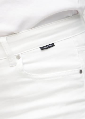 Forlommen på et par hvide slim jeans, hvor man kan se logoet på en plus-size model.