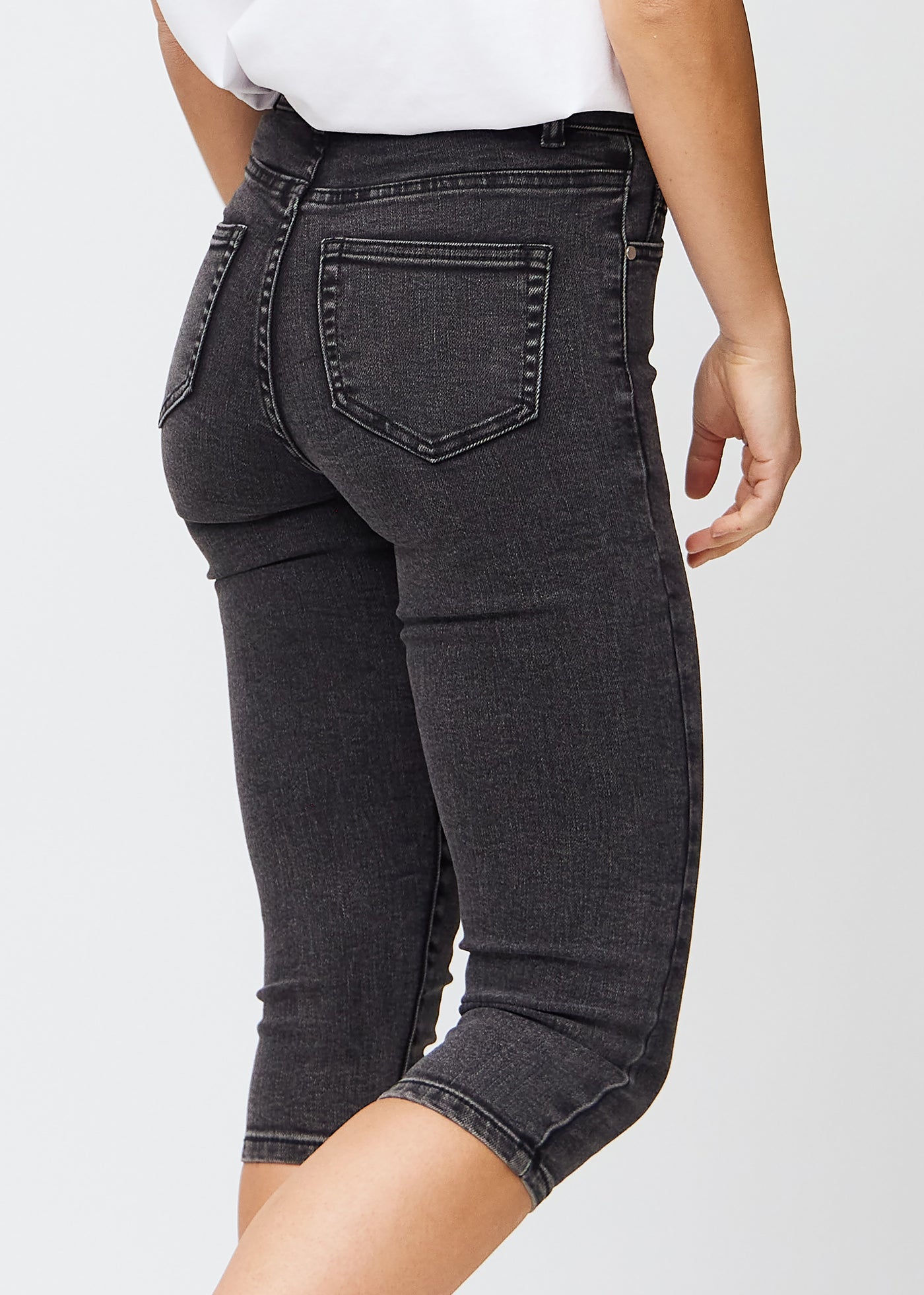 Mørkegrå denim skinny capris set bagfra tæt på for at vise detaljer.