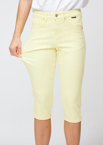 Model strækker caprisene ved låret for at vise det bløde og fleksible stretch.
