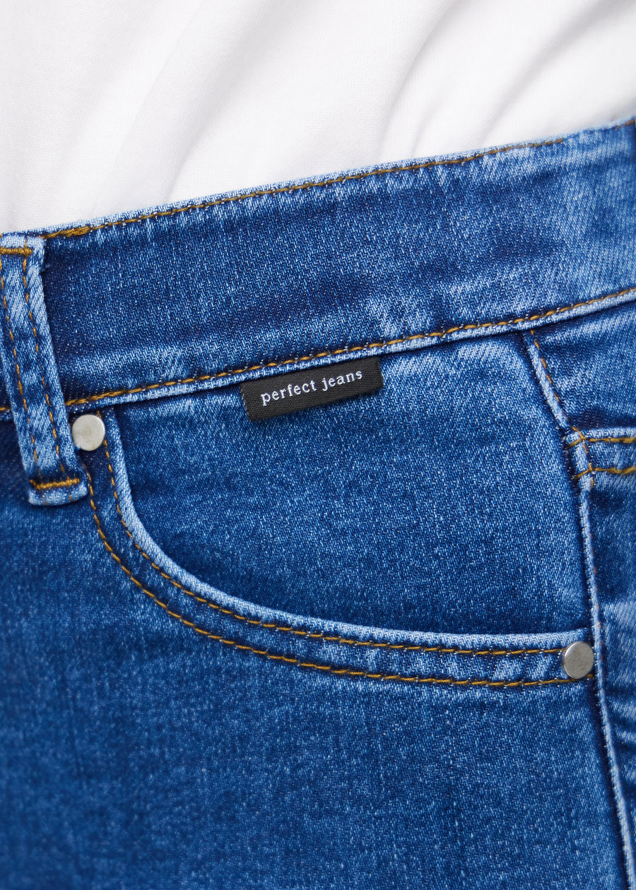 Nahaufnahme von dunkelblauem Denim mit Perfect Jeans Logoetikett an der Vorderkante der Tasche.
