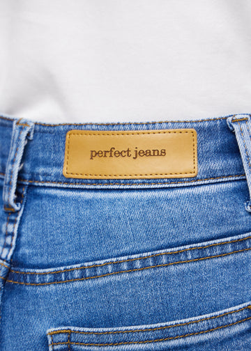 Nahaufnahme von blauem Denim mit Perfect Jeans Lederpatch hinten am Bund.