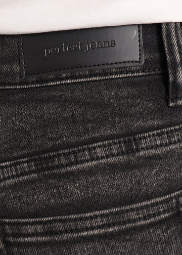 Nærbillede af mørkegrå denim med Perfect Jeans læderpatch bagpå i taljen.
