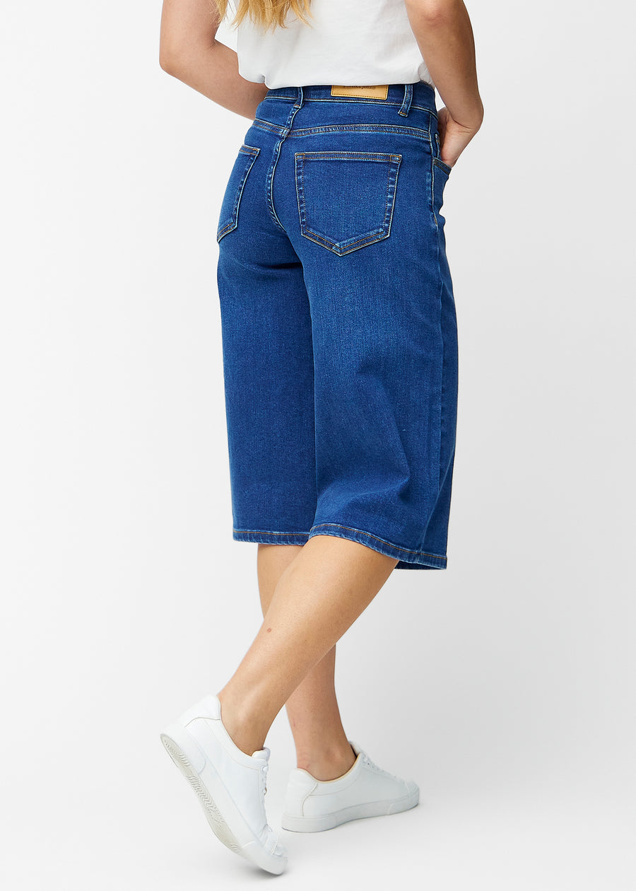 Løse, mørkeblå denim capris i farven Oceans set bagfra, så pasform og længde kan ses.
