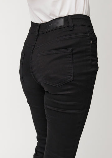 Schwarze Mid-Rise-Bootcut-Jeans in der Farbe Ravens. Nahaufnahme der Rückseite an einem Model, um Details zu zeigen.