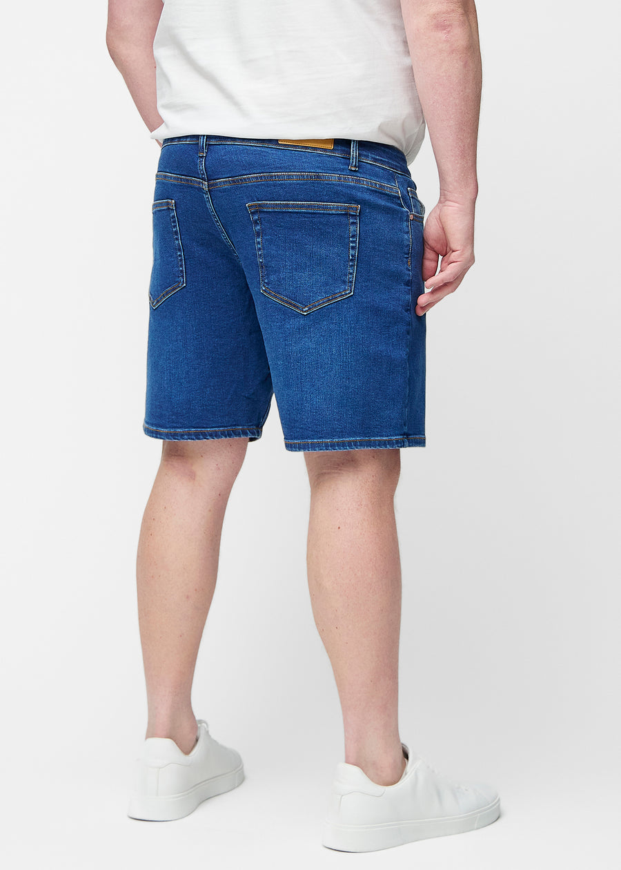 Dunkelblaue Denim-Shorts für Herren in der Farbe Oceans von hinten am Plus-Size-Modell gesehen.