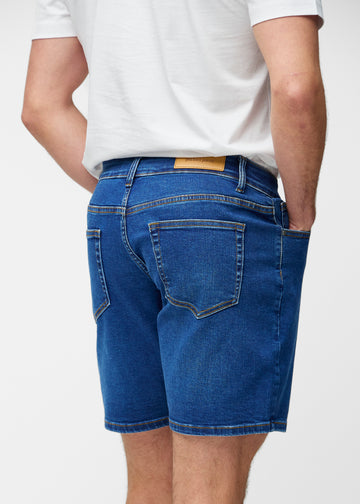 Dunkelblaue Denim-Shorts für Herren in der Farbe Oceans von hinten in Nahaufnahme, um Passform und Details zu zeigen.