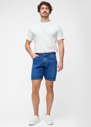 Ganzkörperbild eines Modells in dunkelblauen Denim-Shorts für Herren in der Farbe Oceans mit Regular-Passform.