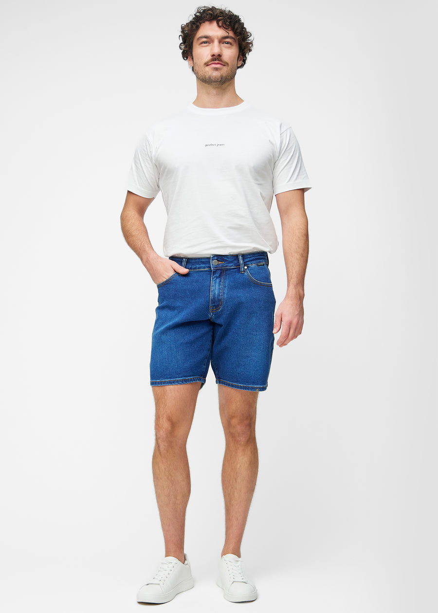 Ganzkörperbild eines Modells in dunkelblauen Denim-Shorts für Herren in der Farbe Oceans mit Regular-Passform.