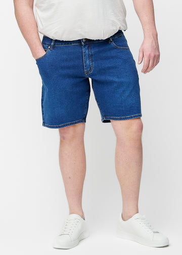 Ganzkörperbild eines Modells in dunkelblauen Denim-Shorts für Herren in der Farbe Oceans mit Regular-Passform.