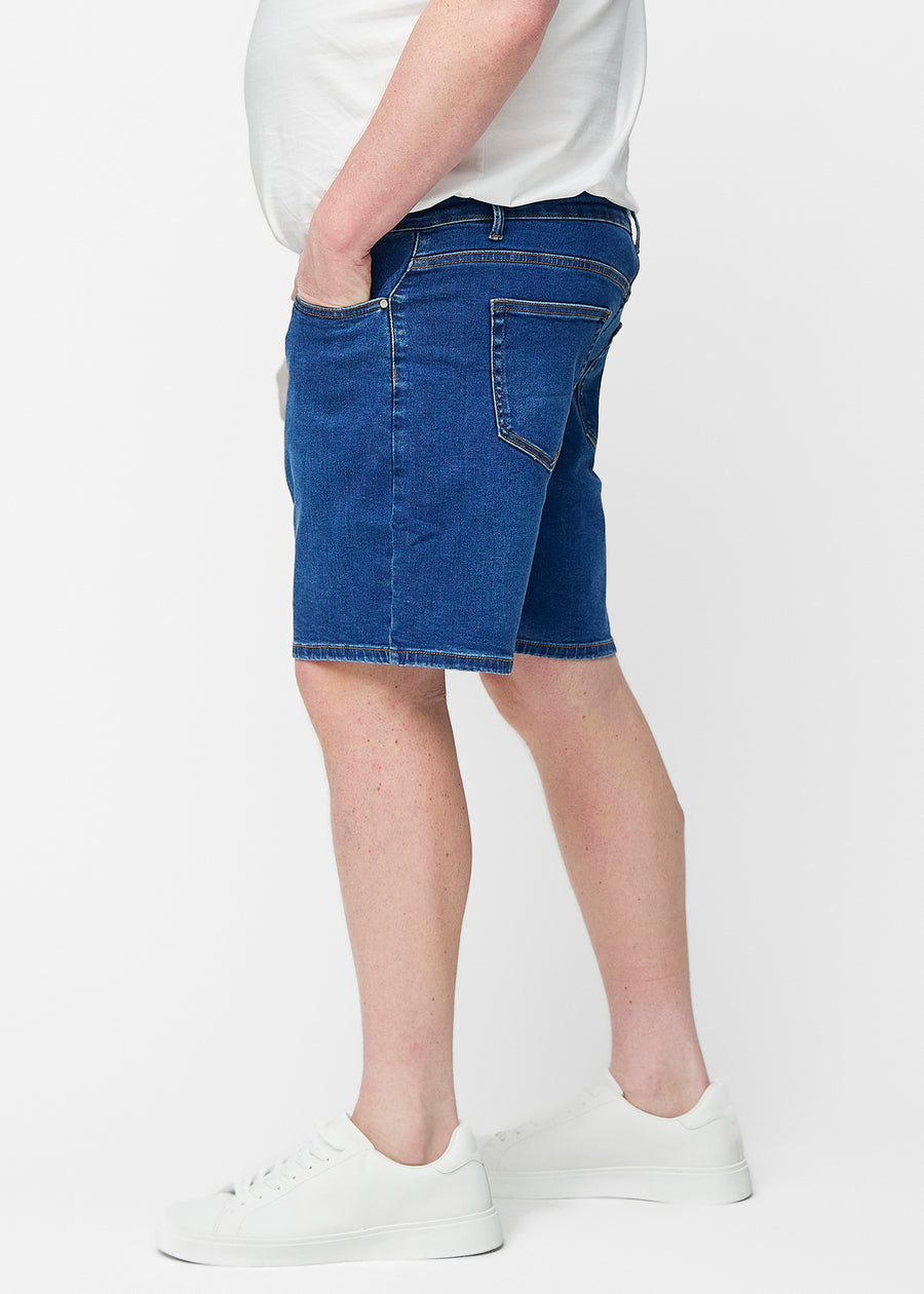 Dunkelblaue Denim-Shorts für Herren in der Farbe Oceans mit Regular-Passform von der Seite am Plus-Size-Modell gesehen.
