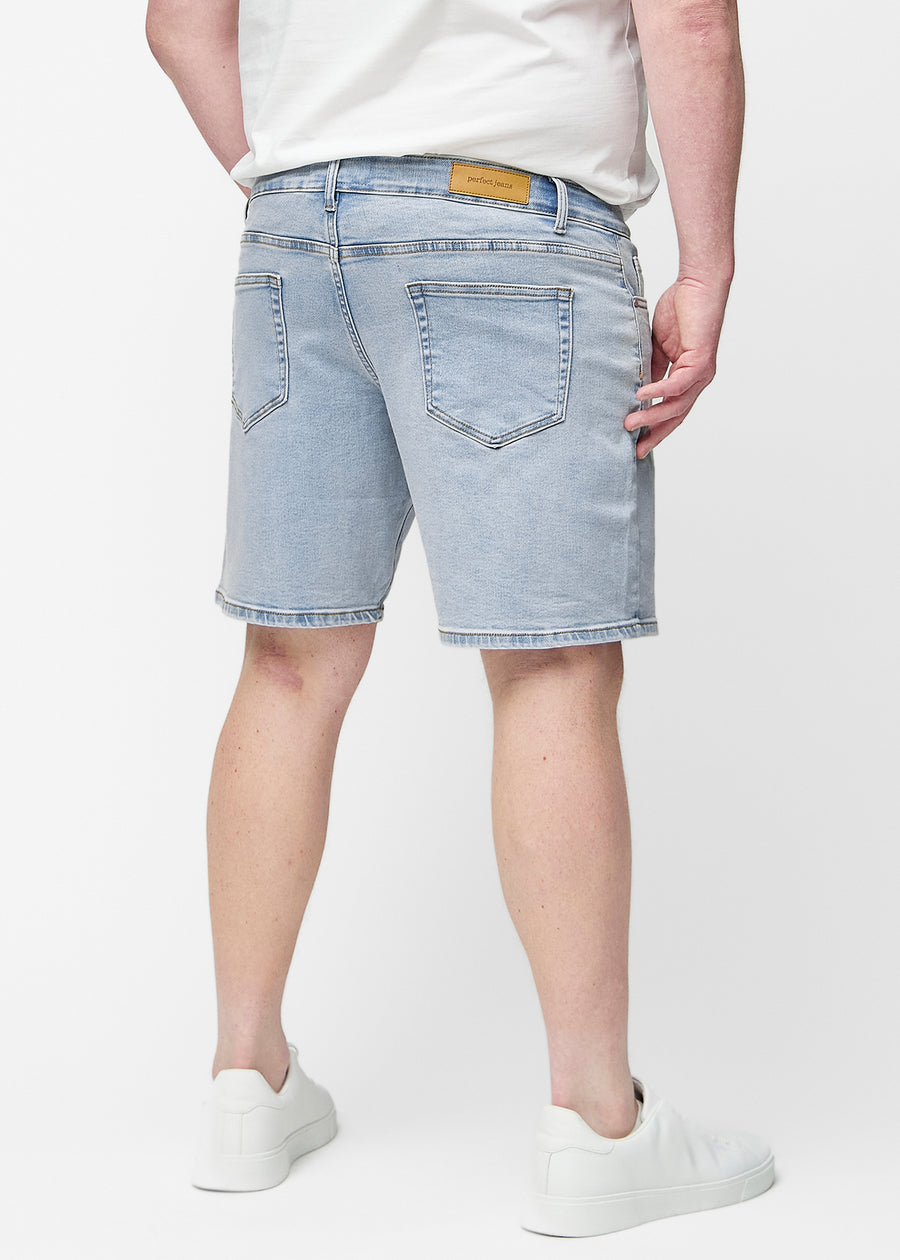 Hellblaue Denim-Shorts für Herren in der Farbe Waves mit Regular-Passform von der Seite am Plus-Size-Model gesehen.