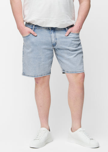 Hellblaue Denim-Shorts für Herren in der Farbe Waves mit Regular-Passform von vorne am Plus-Size-Model, die natürlich an der Hüfte sitzen und Luft um die Oberschenkel lassen.