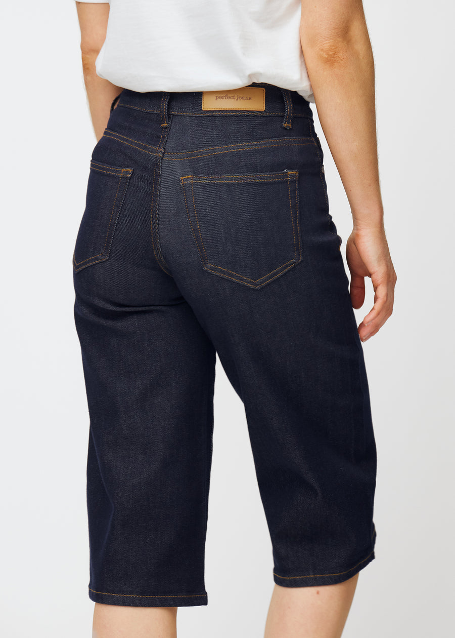 Tief dunkelblaue Denim-Capris für Damen in der Farbe Midnights von hinten nah aufgenommen, um Passform und Details zu zeigen.