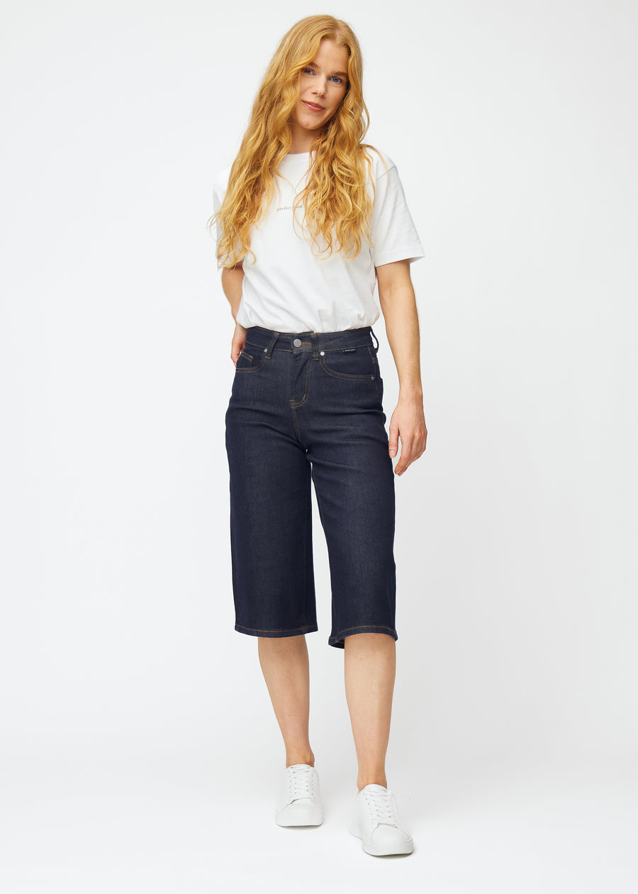 Ganzkörperbild eines Models in tief dunkelblauen Denim-Capris für Damen in der Farbe Midnights mit Loose-Passform.