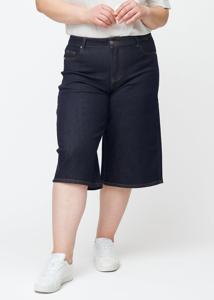 Tief dunkelblaue Denim-Capris für Damen in der Farbe Midnights mit Loose-Passform, von vorne auf einem Plus-Size-Model gesehen.