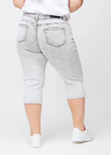 Hellgraue Denim-regular-Capris von hinten an einem Plus-Size-Model gesehen, sodass man das gesamte Produkt sehen kann.