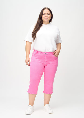 Ganzkörperbild eines Plus-Size-Models in hellrosa regular Capris.