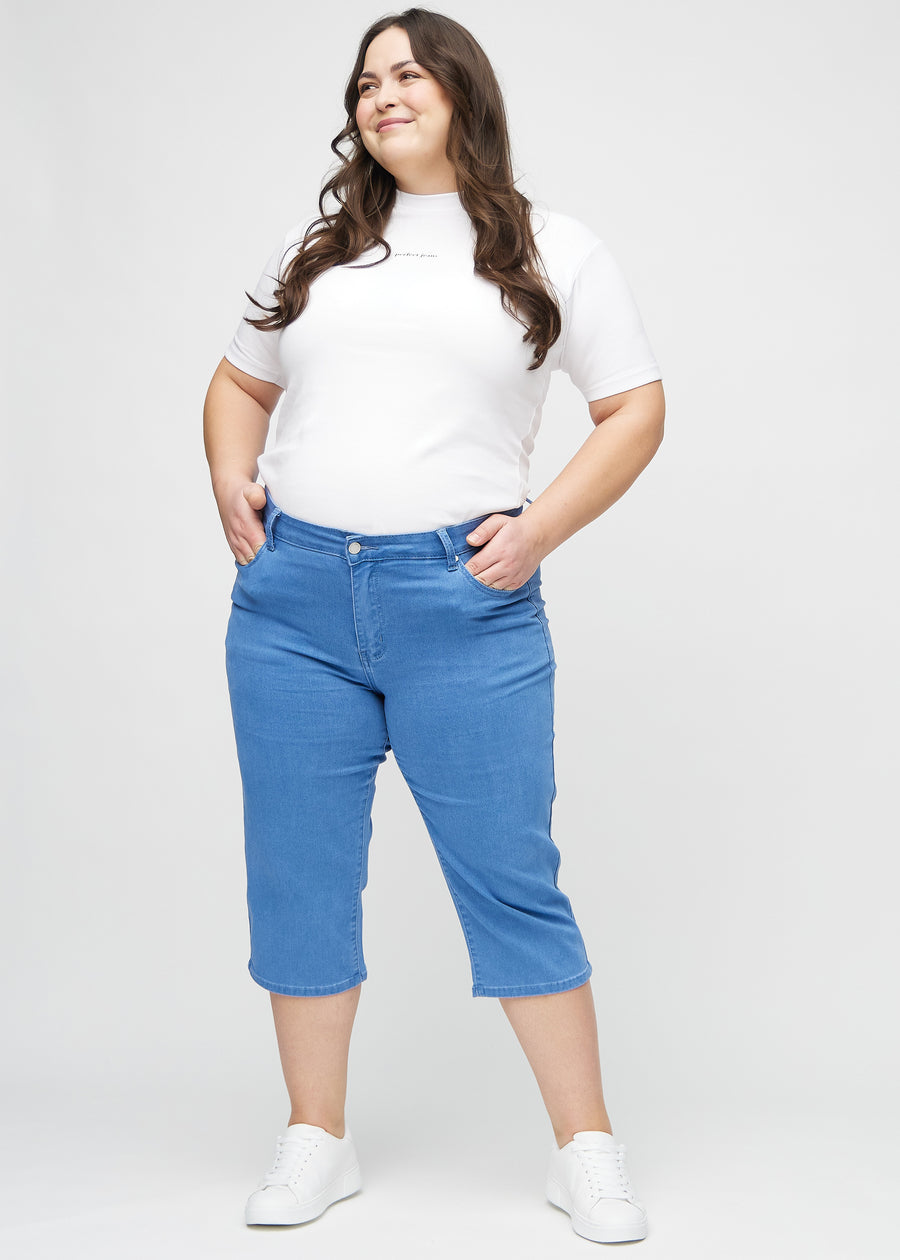Ganzkörperbild eines Plus-Size-Models in blauen regular Capris.