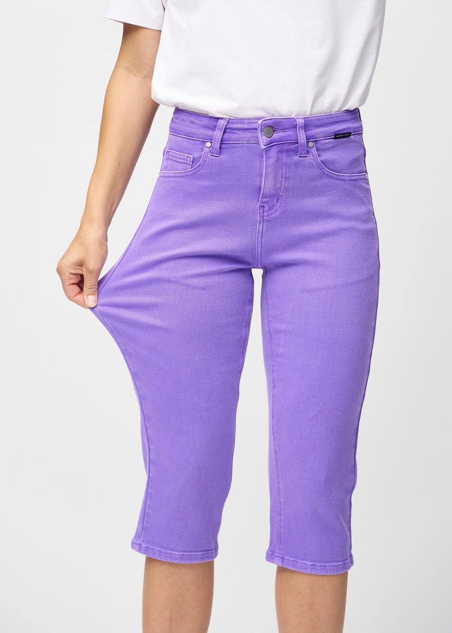 Das Model zieht die Capris am Oberschenkel auseinander, um den Stretch zu zeigen.