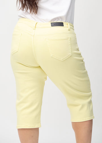 Hellgelbe regular Capris von hinten aus der Nähe an einem Plus-Size-Model gesehen, um Details zu zeigen.