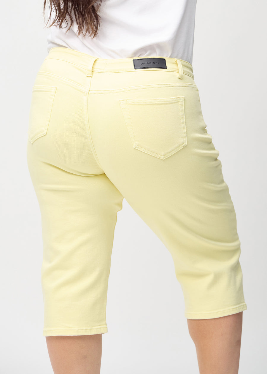 Hellgelbe regular Capris von hinten aus der Nähe an einem Plus-Size-Model gesehen, um Details zu zeigen.
