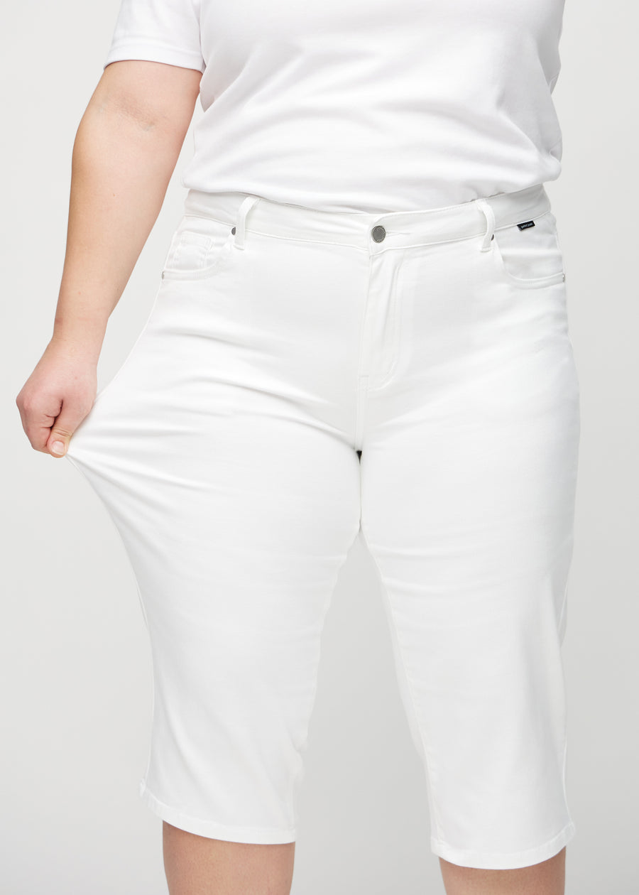 Das Plus-Size-Model zieht die Capris am Oberschenkel auseinander, um den Stretch zu zeigen.