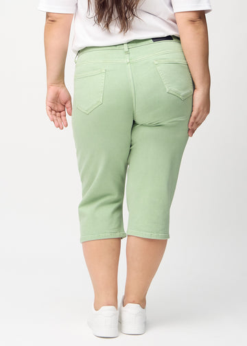 Hellgrüne regular Capris von hinten an einem Plus-Size-Model gesehen, sodass man das gesamte Produkt sehen kann.