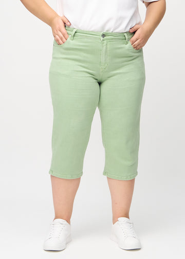 Hellgrüne regular Capris, Modellname Mints, die am Bein gerade heruntergehen, an einem Plus-Size-Model von vorne gesehen.
