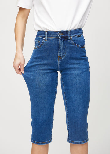 Das Model zieht die Capris am Oberschenkel, um den Stretch zu zeigen.