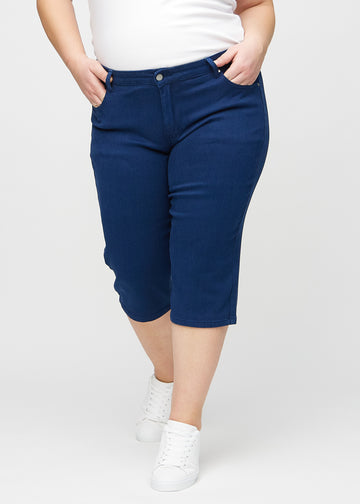 Dunkelblaue regular Capris, Modellname Royals, die eng am Bein anliegen und direkt unter dem Knie enden, an einem Plus-Size-Model von vorne gesehen.