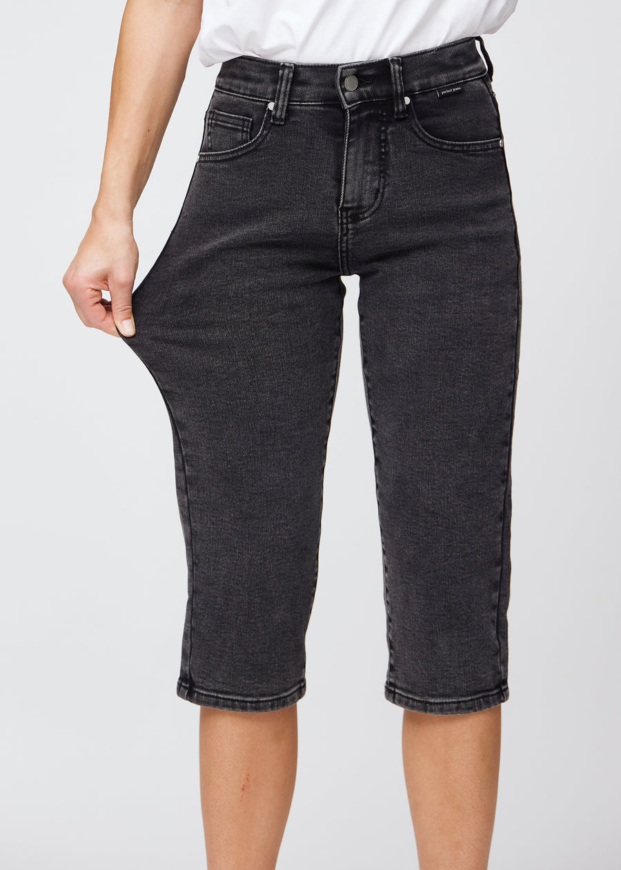 Das Model zieht die Capris am Oberschenkel auseinander, um den Stretch zu zeigen.