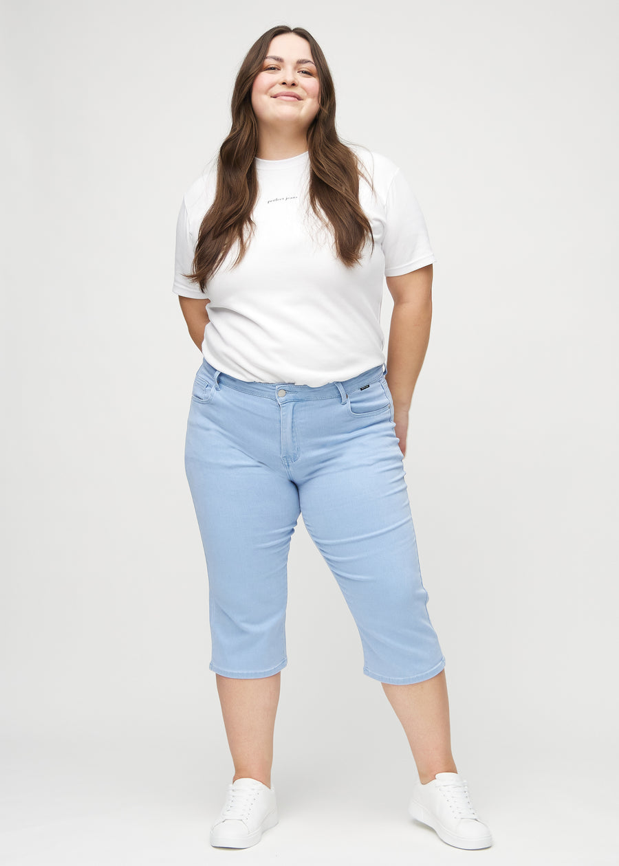 Ganzkörperbild eines Plus-Size-Models in hellblauen regular Capris.