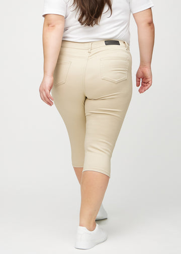 Skinny-Capris für Damen in beigefarbenem Jeansstoff, Farbe Gazelles. Rückansicht an einem Plus-Size-Model, zeigt die Passform und Gesäßtaschen.