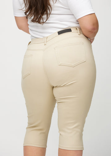 Skinny-Capris für Damen in beigefarbenem Jeansstoff, Farbe Gazelles. Nahaufnahme von hinten an einem Plus-Size-Model, zeigt Taschen und Nähte.