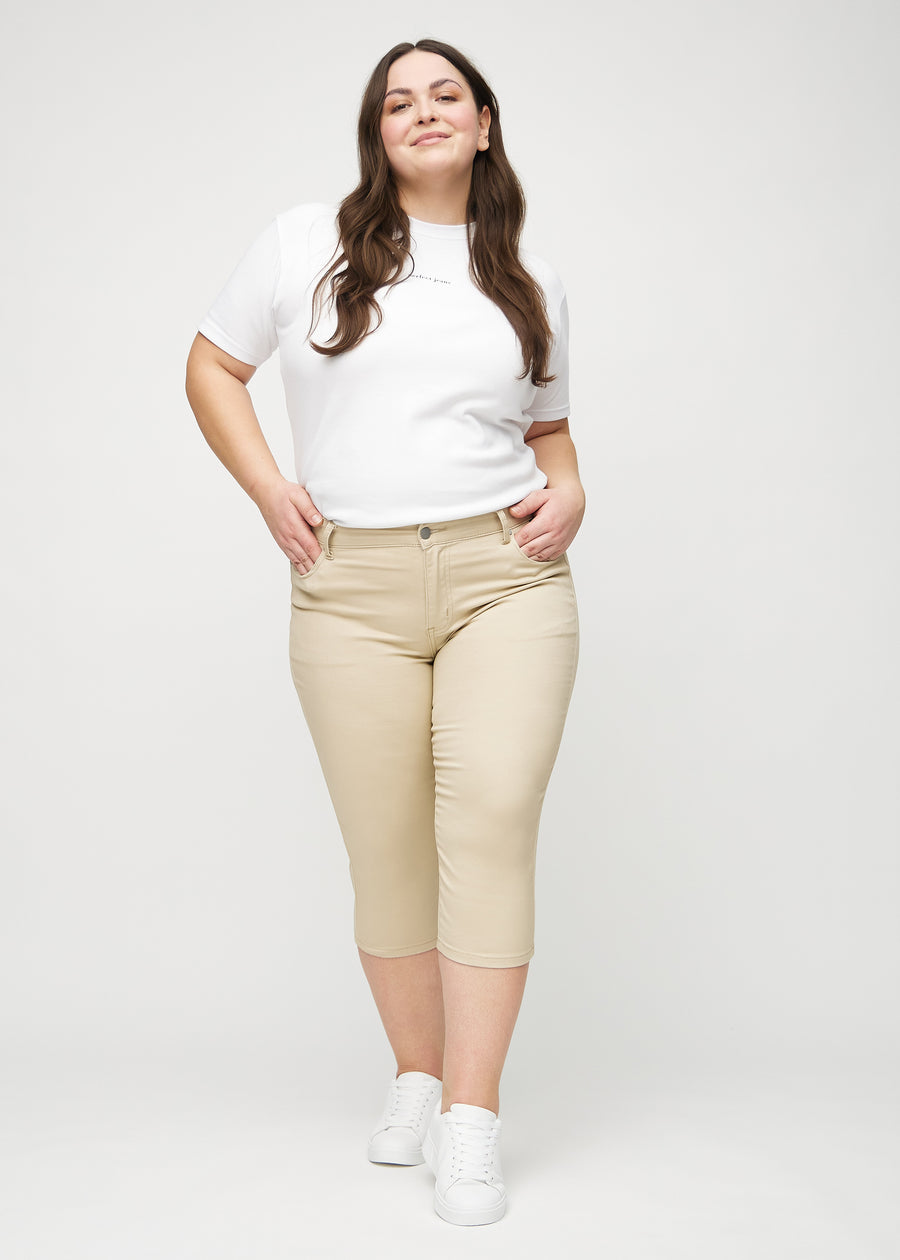 Skinny-Capris für Damen in beigefarbenem Jeansstoff, Farbe Gazelles. Ganzkörperansicht eines Plus-Size-Models in den Capris.