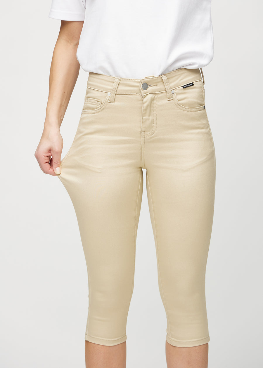 Skinny-Capris für Damen in beigefarbenem Jeansstoff, Farbe Gazelles. Ein Model dehnt den Stoff, um den Stretch zu zeigen.