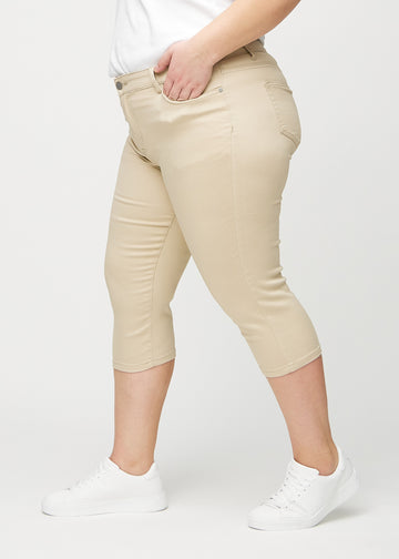 Skinny-Capris für Damen in beigefarbenem Jeansstoff, Farbe Gazelles. Seitenansicht an einem Plus-Size-Model, die figurbetonte Passform ist zu sehen.