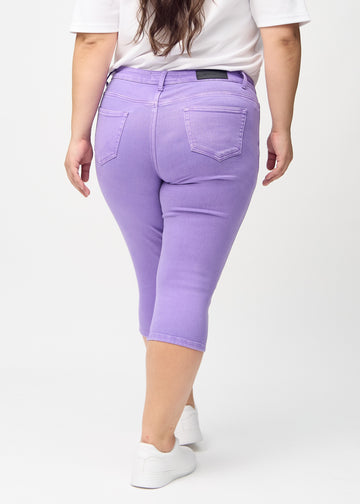 Lila skinny Capris von hinten an einem Plus-Size-Model gesehen, sodass man das gesamte Produkt sehen kann.