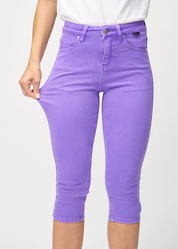 Das Model zieht die Capris am Oberschenkel auseinander, um den Stretch zu zeigen.