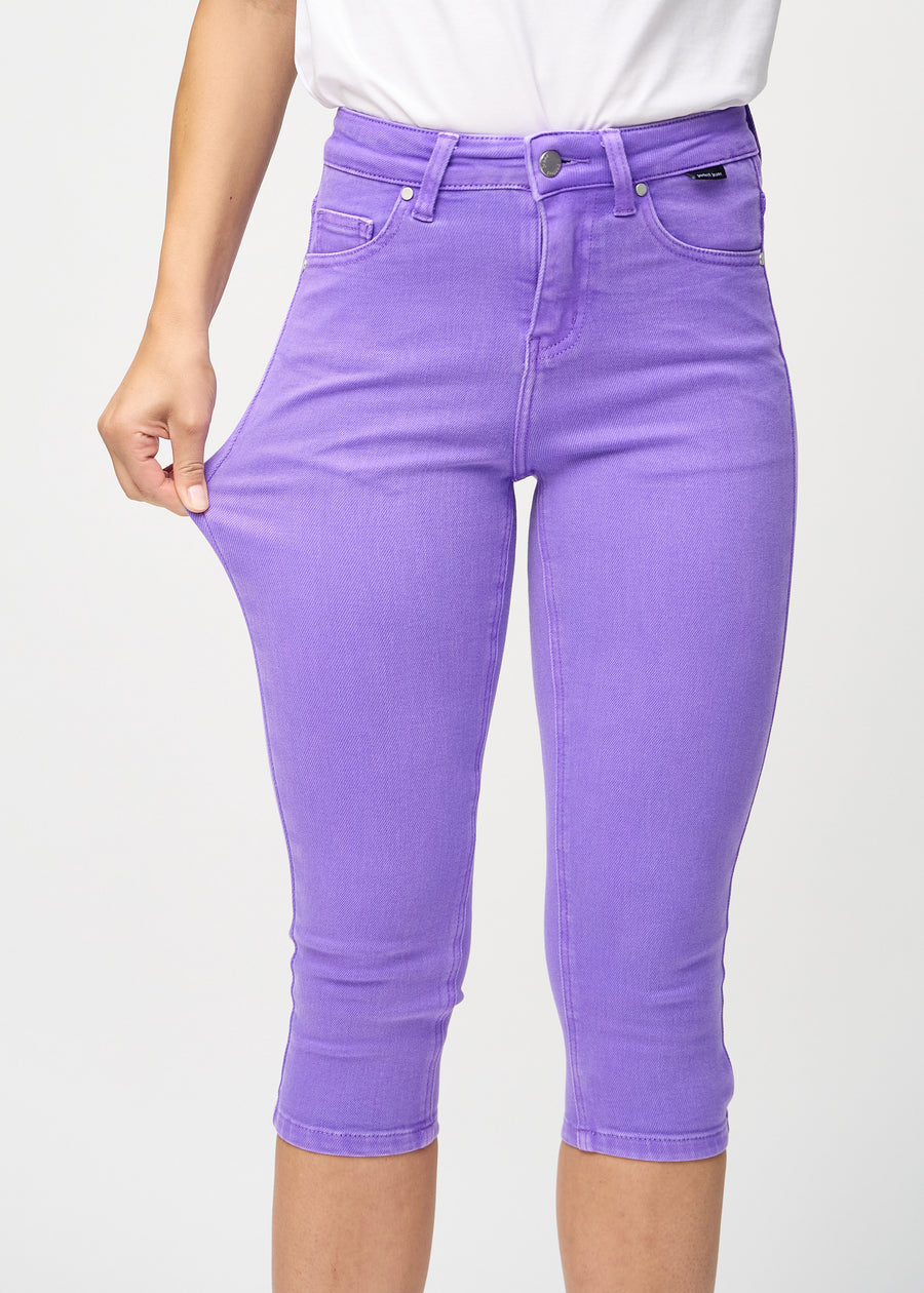 Das Model zieht die Capris am Oberschenkel auseinander, um den Stretch zu zeigen.