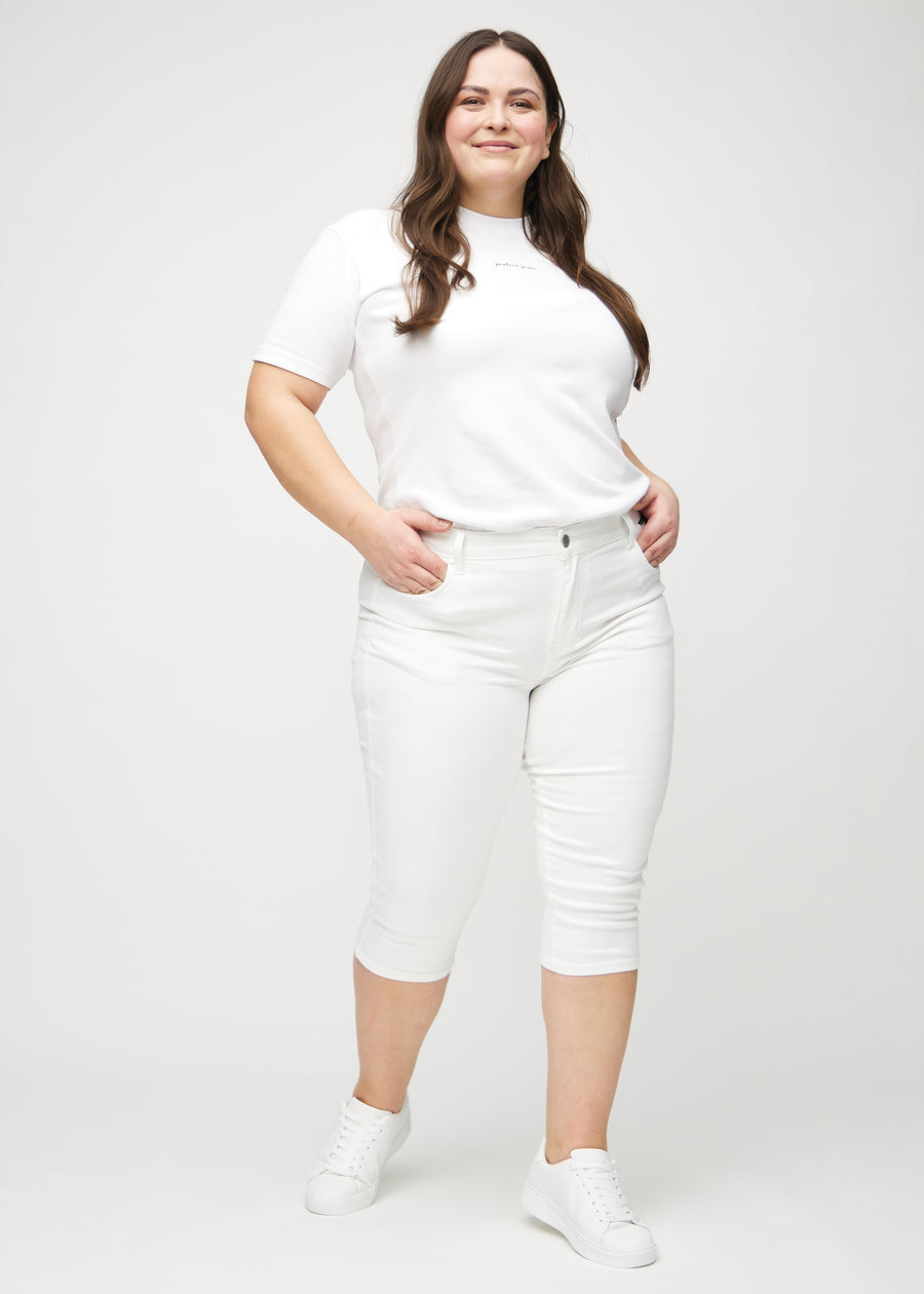 Skinny-Capris für Damen in weißem Jeansstoff, Farbe Marguerites. Ganzkörperansicht eines Plus-Size-Models in den Capris.