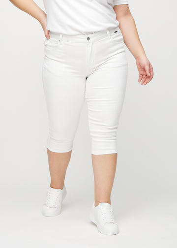 Skinny-Capris für Damen in weißem Jeansstoff, Farbe Marguerites. Vorderansicht an einem Plus-Size-Model, eng geschnitten bis knapp unter das Knie.