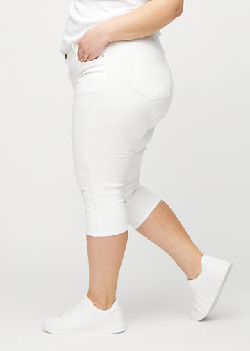 Skinny-Capris für Damen in weißem Jeansstoff, Farbe Marguerites. Seitenansicht an einem Plus-Size-Model, die figurbetonte Passform ist zu sehen.