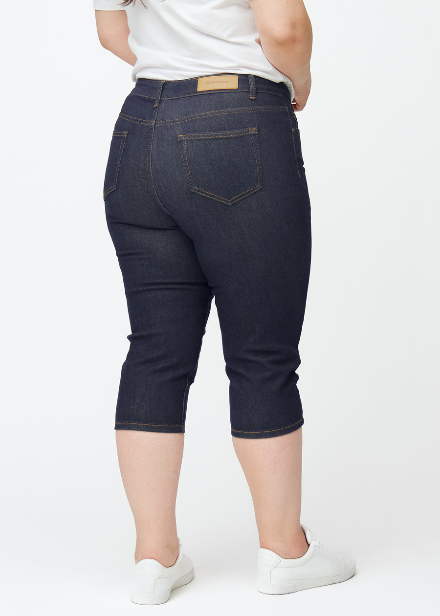 Tief dunkelblaue Denim-Capris für Damen in der Farbe Midnights von hinten auf einem Plus-Size-Model gesehen.