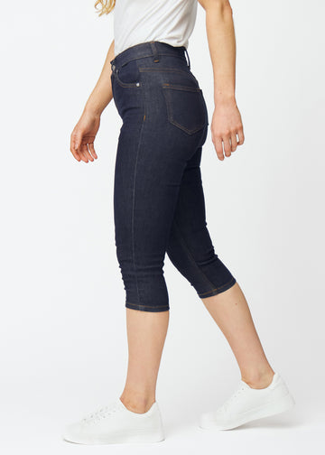 Tief dunkelblaue Denim-Capris für Damen in der Farbe Midnights mit Skinny-Passform, von der Seite am Model gesehen.